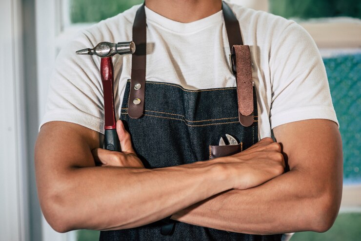 carpenter-stands-holds-hammer wear leather apron