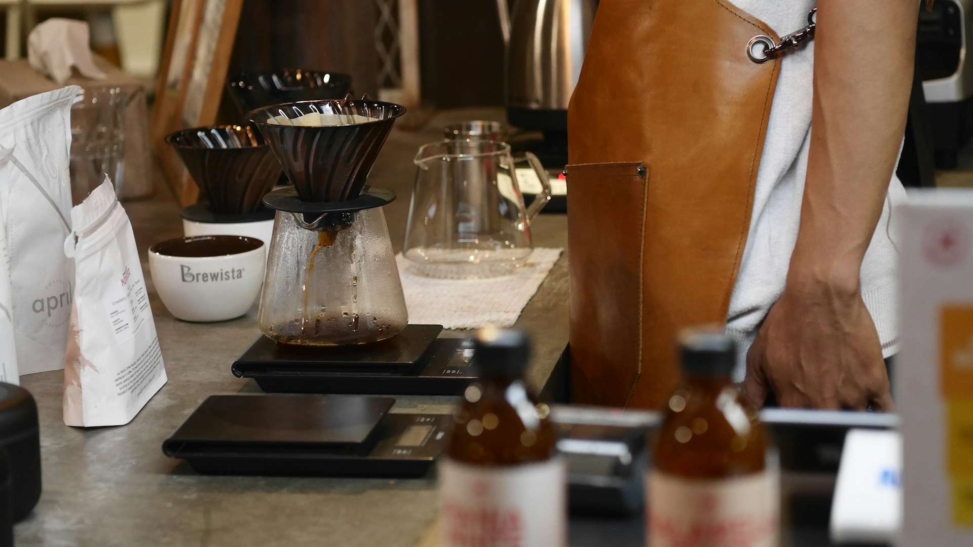 Barista wearing a leather bar apron preparing coffee